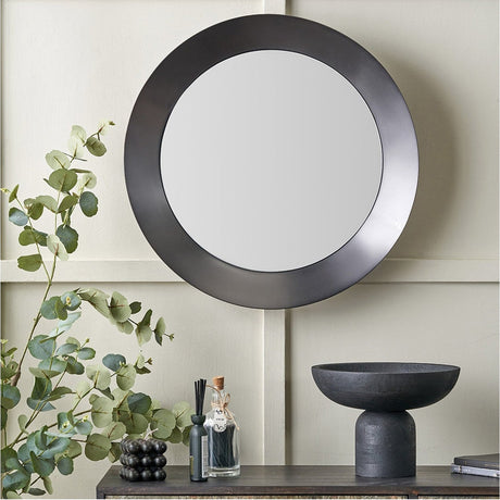 Round wall mirror with an angled graphite aluminium frame, 60 x 60cm, shown above a console table with a black bowl and eucalyptus stems.