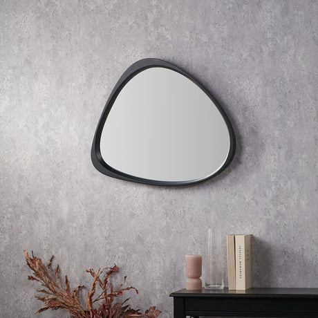 Black wood veneer curved wall mirror, 67 x 58cm, with an organic pebble-shaped frame, shown on a grey textured wall above a black console table.