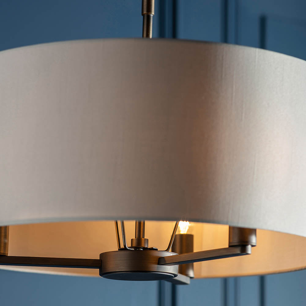 Endon Bexley large 3 light pendant with marble-effect faux silk drum shade and dark antique bronze frame, shown against a deep blue panelled wall.