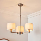 Endon Bexley 3 Light Pendant in antique bronze with three marble-effect faux silk shades on curved arms, mounted to a white ceiling.