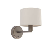 Endon Bexley wall light in bronze with a brushed arm, circular backplate and cream faux silk drum shade, shown on a plain white background.