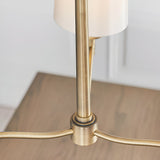 Close-up of Endon Castwell 3 Light Pendant showing matt antique brass central hub, arms and stem with vintage white fabric shade above a wooden table.