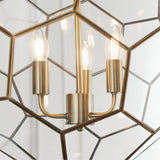 Close-up of Endon Carldon 3 Light Pendant in antique brass, showing three lit E14 candle bulbs on brass holders within hexagonal clear glass panels.