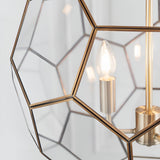 Close-up of Endon Carldon 3 Light Pendant in antique brass with hexagonal clear glass panels and a lit E14 candle bulb on a brass lampholder.