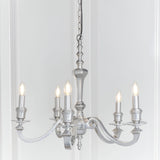 Endon Brambourne 5 light pendant in polished aluminium with curved arms and candle-style lampholders, suspended from a chain against a white panelled wall.