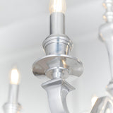 Close-up of the Endon Brambourne pendant showing a polished aluminium candle arm, tiered central column and lit E14 candle-style bulb above.