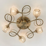 Endon Harcourt 5 light semi-flush ceiling light in antique brass, viewed from below showing looped arms and mesh-caged glass shades around a circular plate.