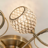 Close-up of one crystal-beaded globe shade on the Endon Harcourt 5 Light Semi-Flush Ceiling Light in antique brass, showing the curved arms.