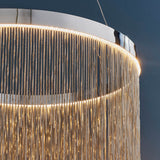 Danestead Pendant in polished chrome, close-up of fine chain strands cascading from a ring of integrated LED light, set against a dark background.
