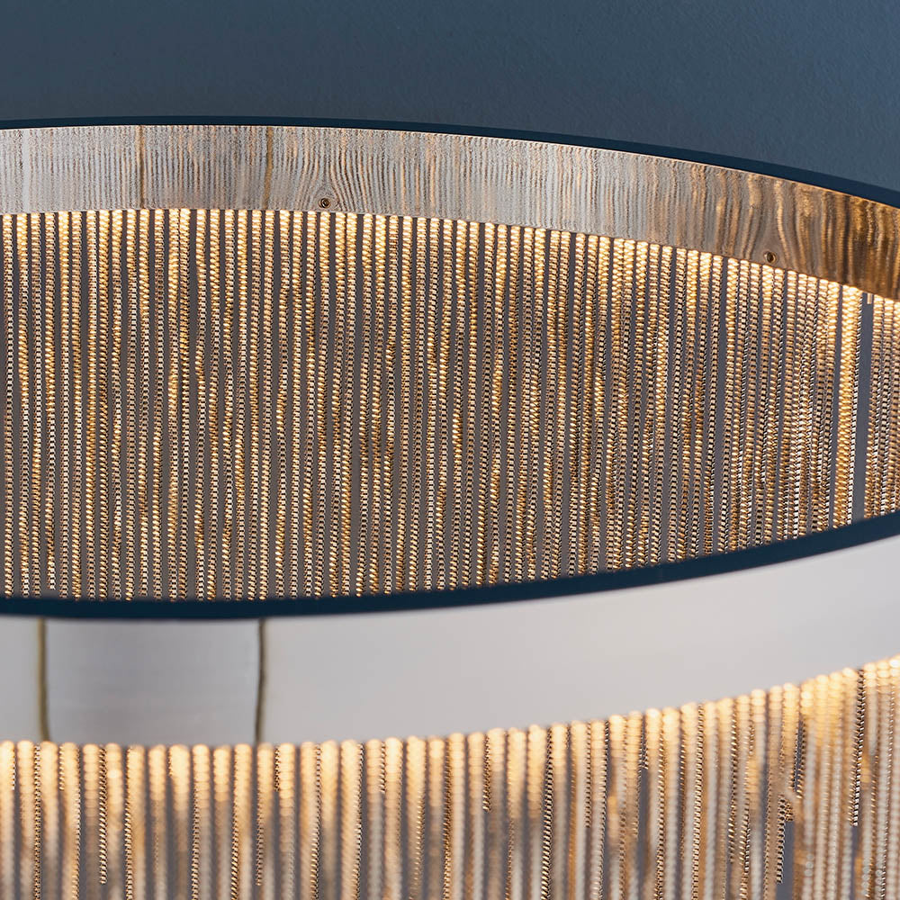 Close-up of the Danestead Pendant in polished chrome, showing fine chains cascading from a ring of LED light for a shimmering effect.