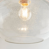 Close-up of the Endon Brackcombe clear bubble glass pendant shade, rounded open form, lit E27 filament bulb visible through the seeded glass.