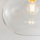 Close-up of the Endon Brackcombe clear bubble glass pendant shade with a lit E27 filament lamp visible inside, shown against a plain light background.