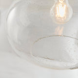 Close-up of Endon Brackcombe pendant shade in clear bubble glass with an exposed filament E27 lamp glowing inside.