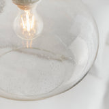 Close-up of the Endon Brackcombe clear bubble glass pendant shade with an exposed filament E27 lamp glowing inside the rounded globe.