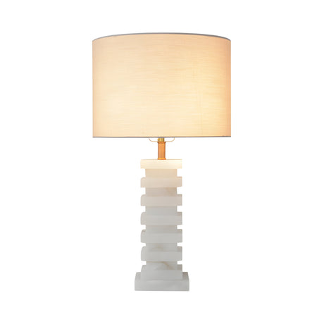 The Echelon 1 Light Stepped Alabaster Table Lamp in Brass & Soft White features a geometric alabaster base and a cylindrical beige shade, casting a soft glow that enhances any space with sculptural elegance.