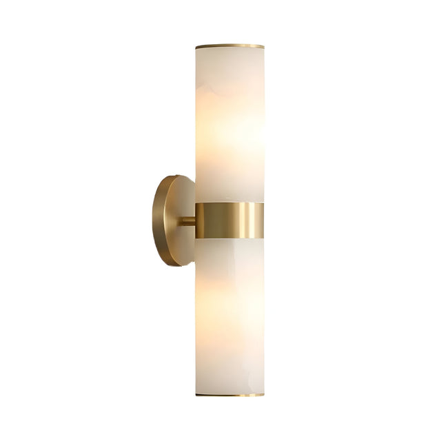 The Elaris 2 Light Double Cylinder Alabaster Wall Light in soft white and brass features dual alabaster shades and a brass round base, mounted vertically to emit a gentle glow from both ends for modern elegance.