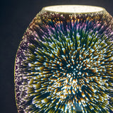 Close-up of the Endon Cliffwick touch table lamp showing its holographic glass body with a colourful starburst light effect against a dark background.