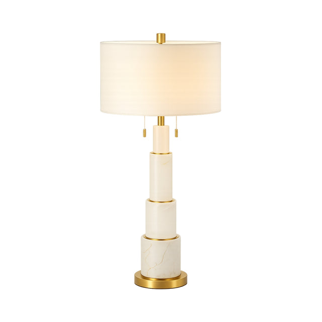 The Eloria 1 Light Stacked Alabaster Table Lamp features a brass and soft white tiered base, gold accents, and a white cylindrical shade, creating a modern and elegant look.