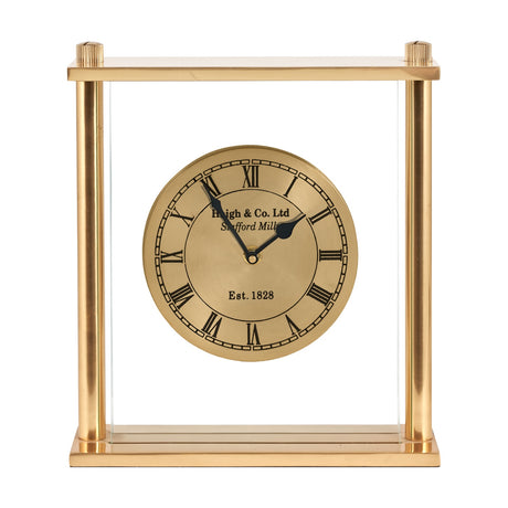 Gold brass mantel clock, 28cm, with a rectangular open frame, glass panels, and a round gold clock face floating inside, set against a plain white background.