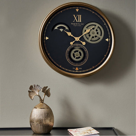 Round black and champagne wall clock, 50cm, with exposed gear detail and Roman numeral XII, shown above a console table with a decorative vase.