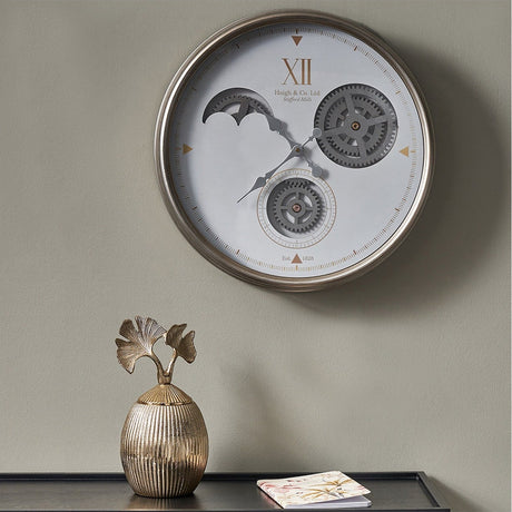 White & Silver Iron Working Cog Wall Clock, 50cm, with visible gear mechanism and Roman numeral XII, mounted above a console table with a decorative vase.
