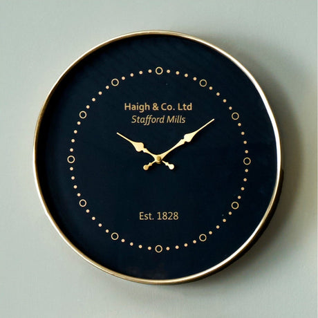 Round wall clock, 38cm, black face with antique brass frame and hands, dotted hour markers, "Haigh & Co. Ltd Est. 1828" text, on a plain grey background.
