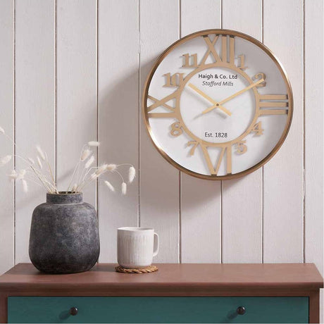 Gold Iron & White Face Round Wall Clock, 40cm, with Roman and Arabic numerals, gold hands, and glass cover, shown mounted above a console table.