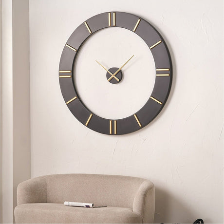 Black & Gold 2 Piece Open Wall Clock, 120cm, with an open black ring frame, gold hour markers and gold hands, displayed above a beige sofa in a living room.