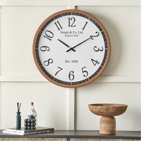 Round wall clock, 61cm, with white face, bold black numerals, and dark wood-effect frame, shown mounted above a sideboard with decor accessories.
