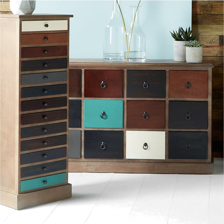 Blue multicoloured pine 12 drawer unit with mixed teal, cream, and dark fronts, shown beside a matching tall narrow drawer unit in a room setting.