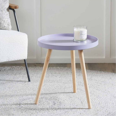 Halston Lilac Wood Veneer & Pine Side Table, 43cm, round lilac tray-style top on splayed natural wood legs, shown beside an armchair in a living room setting.