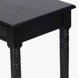 Close-up of the Heritage Black Pine Console Table, 80cm, showing a black wood tabletop with overhang above turned legs and a frame apron.
