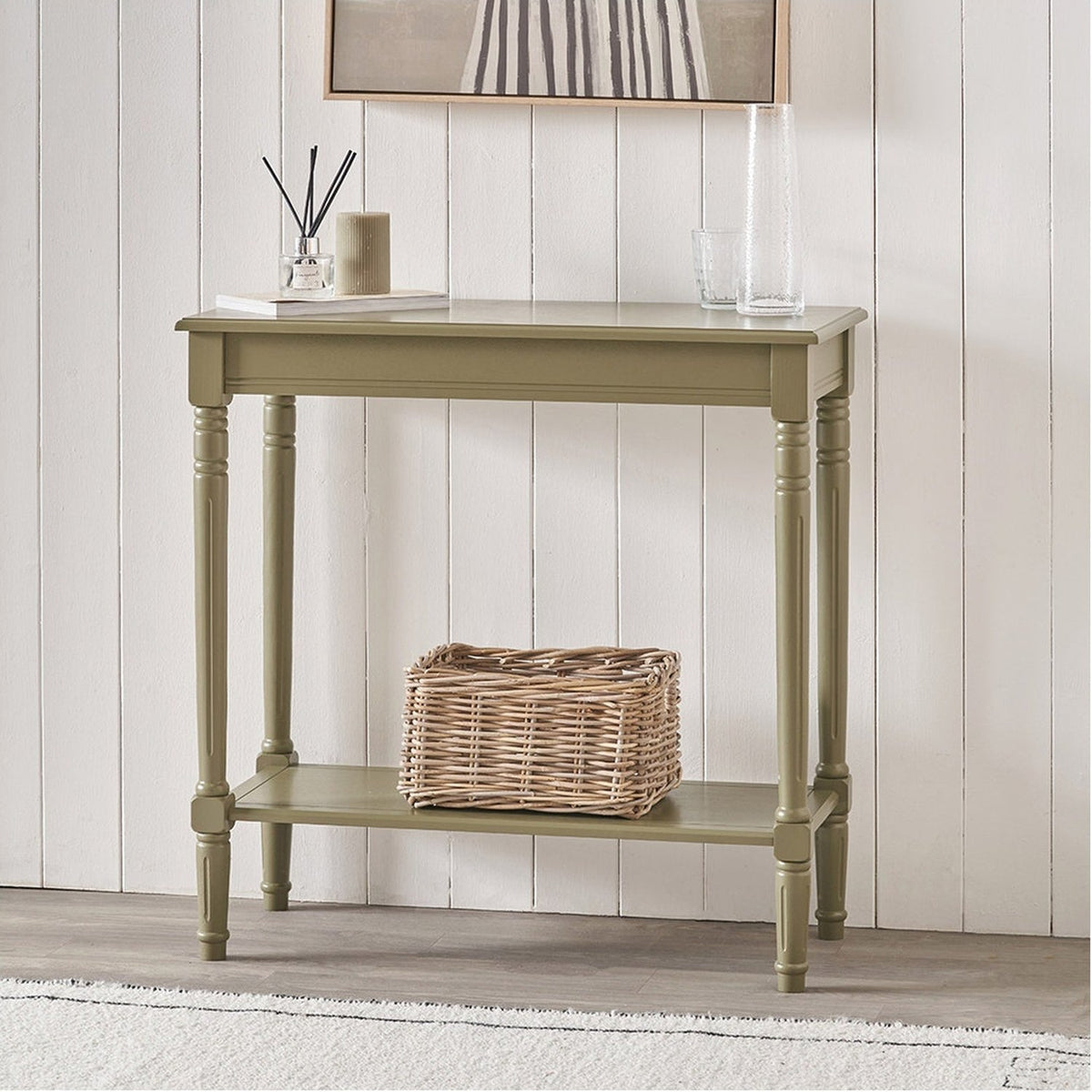Heritage Olive Pine Console Table, an 80cm wood console with turned legs and lower shelf, shown in green finish against a panelled wall in a hallway setting.