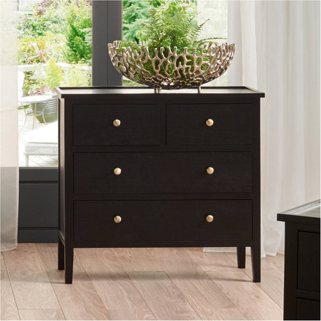 Chelmsford satin black pine 4 drawer chest with gold-tone knobs, shown in a bedroom setting topped with a decorative bowl and plant.