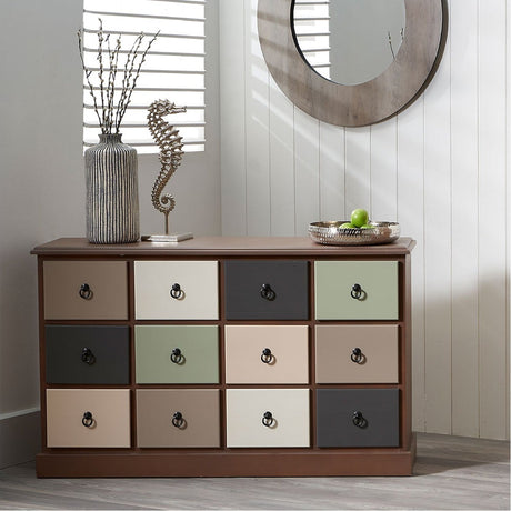 Loft Sage Multicoloured Pine 12 Drawer Unit, wooden chest of drawers with 12 drawers in mixed sage green, cream, taupe and charcoal finishes with ring pulls, shown in a bedroom setting.