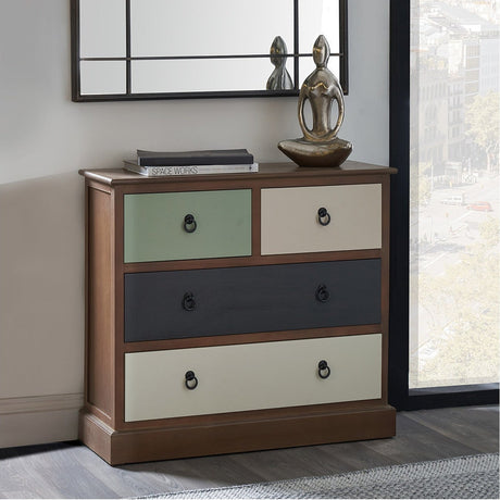 Loft Sage Multicoloured Pine 4 Drawer Unit in a bedroom setting, with sage green, cream, and charcoal drawer fronts, black ring handles, and a wood frame beneath a wall mirror.