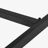 Close-up of the Ukiah dining table's black iron frame joint with grey oak veneer edge visible, shown against a plain white background.