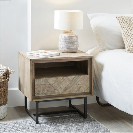 Marca Sand Wash Acacia 1 Drawer Shelving Unit, 55cm, in wood with an open shelf and herringbone-patterned drawer front on a black metal base, shown as a bedside table.