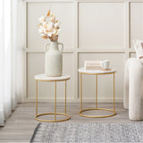 Milly Set of 2 White Marble & Gold Iron Side Tables, 47cm round tables with gold metal frames, styled in a living room with a vase, books, and a mug.