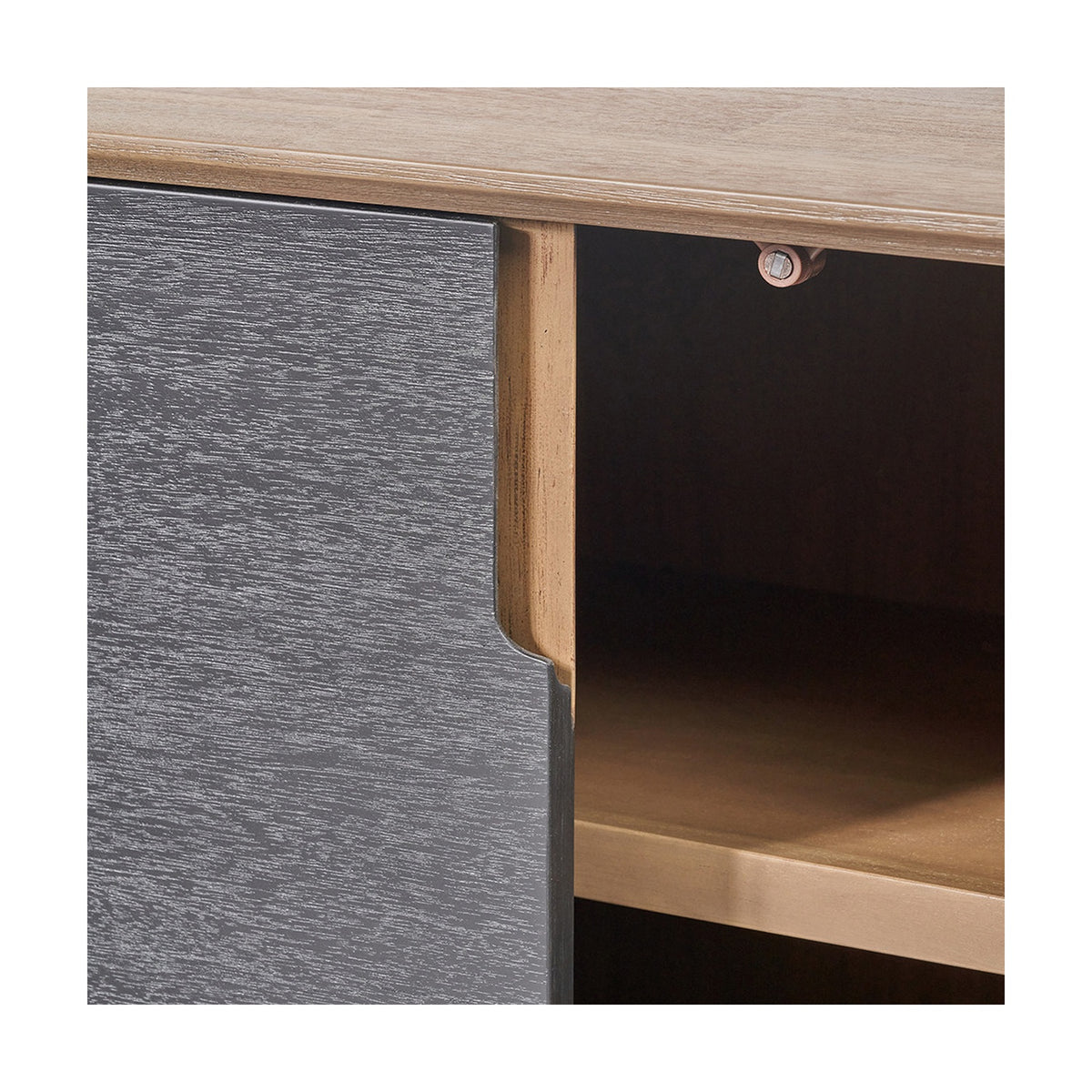 Close-up of the Gio Black & Acacia 4 Door Sideboard, showing a textured black door front against a natural wood frame with an open shelf compartment and brass-toned hinge.