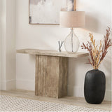 Elkton Concrete Effect Console Table with grooved wood veneer pedestal base, styled in a hallway with a glass table lamp, black vase, and framed wall art.