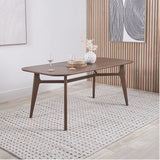 Elias Dark Ash Wood Retro Dining Table with rounded rectangular top, angled tapered legs and cross stretcher, styled in a dining room with a patterned rug and wood-slat wall.