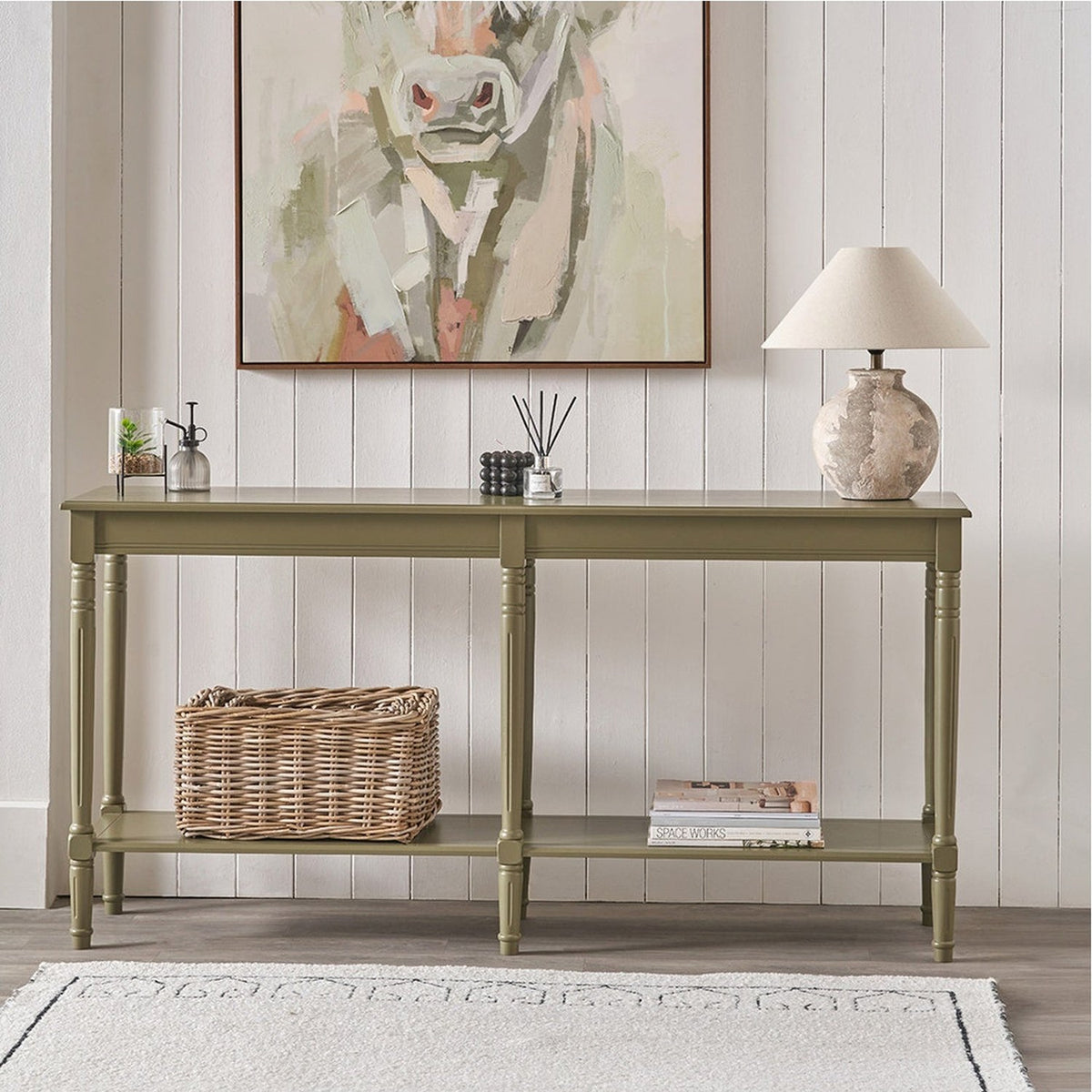 Heritage Olive Pine Large Console Table with turned legs and lower shelf, styled in a hallway with a table lamp, framed artwork, and woven basket.