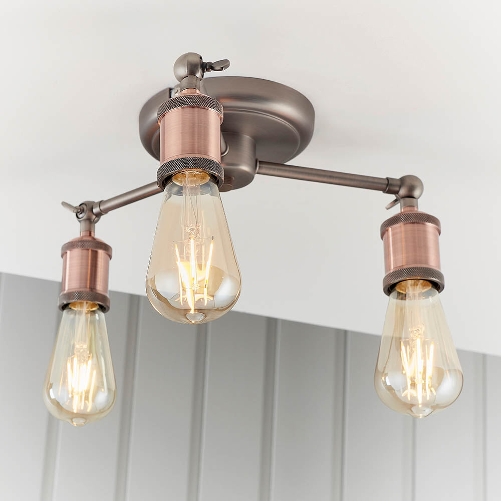 Brackley 3 Light Semi-Flush Ceiling Light in pewter and copper, three angled arms with exposed E27 bulbs, mounted on a white ceiling.