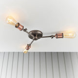 Brackley 3-light semi-flush ceiling light with angled metal arms in pewter and copper finish, fitted with exposed bulbs, shown on a white ceiling.
