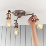Brackley 3 Light Semi-Flush Ceiling Light in pewter/copper with three angled arms, copper holders, and exposed filament bulbs.