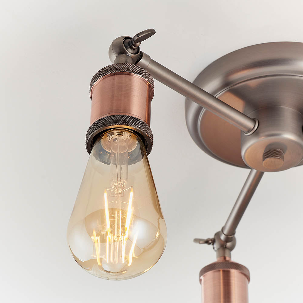 Close-up of the Brackley 3 Light Semi-Flush Ceiling Light in pewter and copper, featuring an adjustable arm and knurled copper lamp holder.