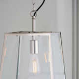 Brenton Lantern Pendant in nickel with tapered glass-panelled frame, black fabric flex, and exposed filament E27 bulb, shown close-up.
