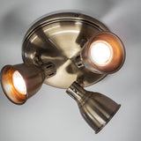 Endon Daneford three-light round spotlight in antique brass, with three adjustable steel heads mounted on a circular ceiling plate.
