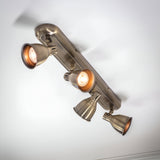 Endon Daneford 4 light spotlight in antique brass, ceiling-mounted with four adjustable heads on a linear plate, two lit, viewed from below.